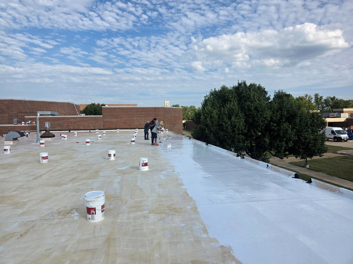 Blue Ox crew applying Gaco silicone coating on a commercial flat roof